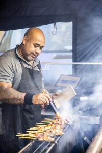 Man cooking meat over coals