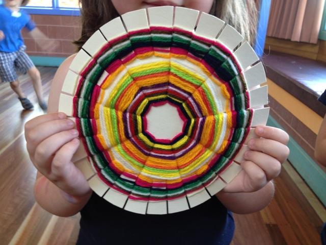 child holding weaving placemat. 