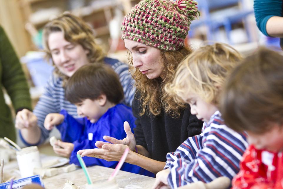 children and adults sculpting with clay