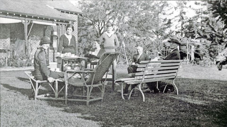 Black and White photograph of a family having a picnic with outdoor furniture