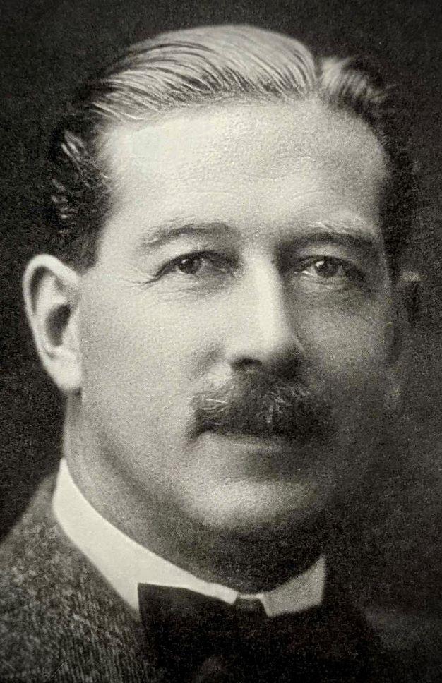 Black and white close-up photograph of man with moustache. 