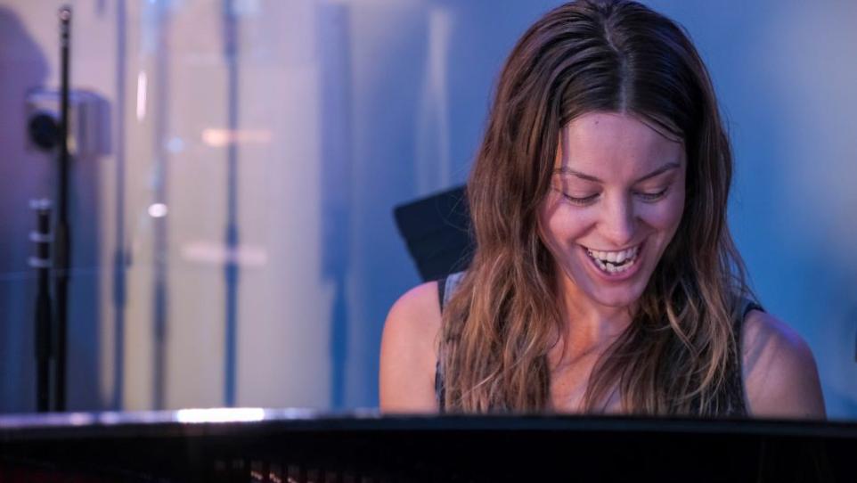 Portrait of a young woman looking down while playing the piano