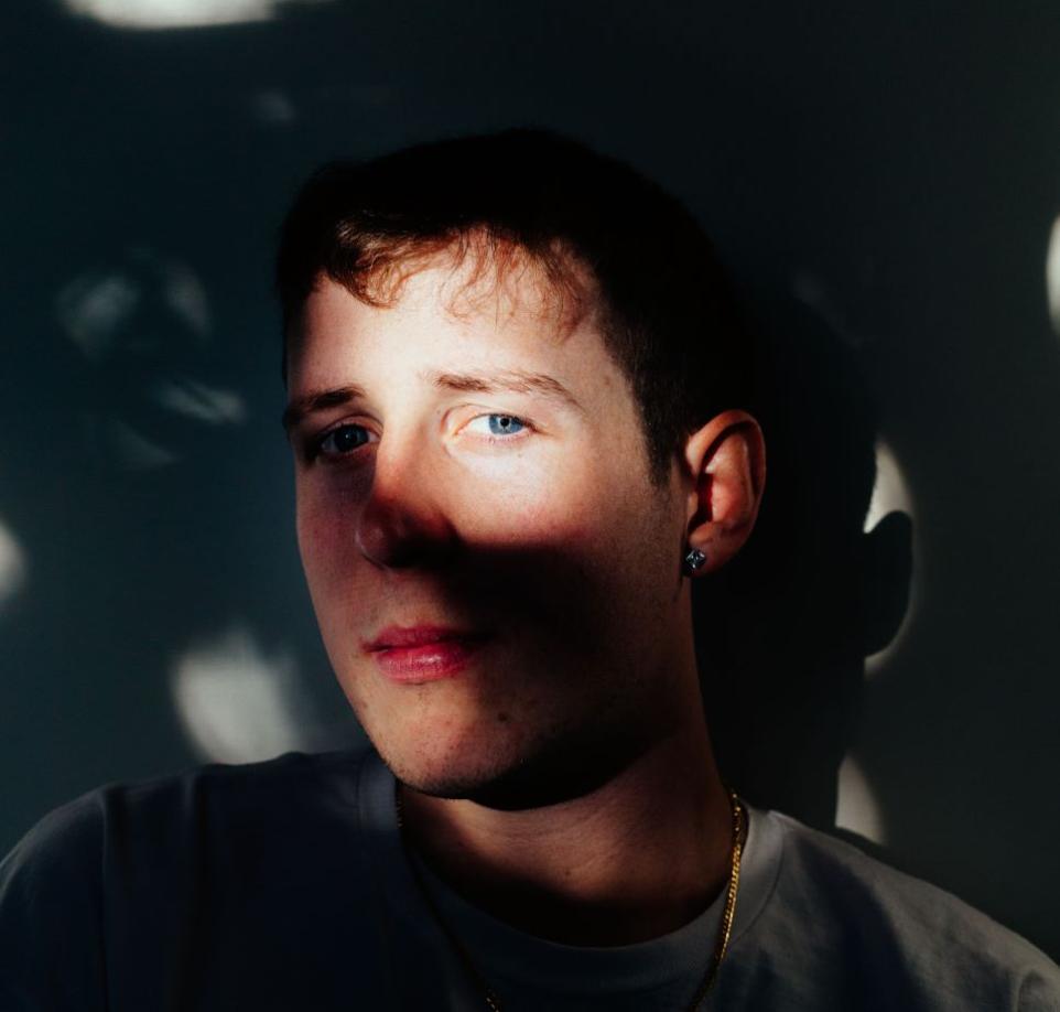 Portrait of a young man looking at the camera though shadows.