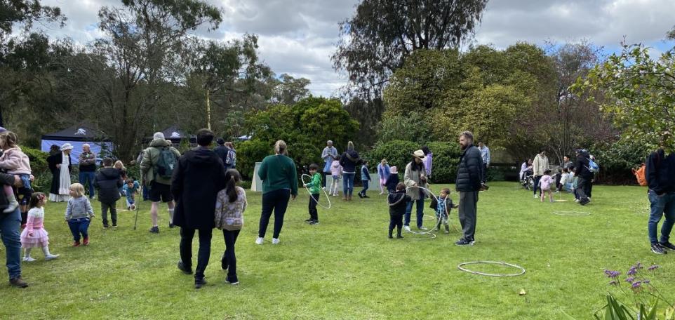 Families playing with hula hoops in a garden