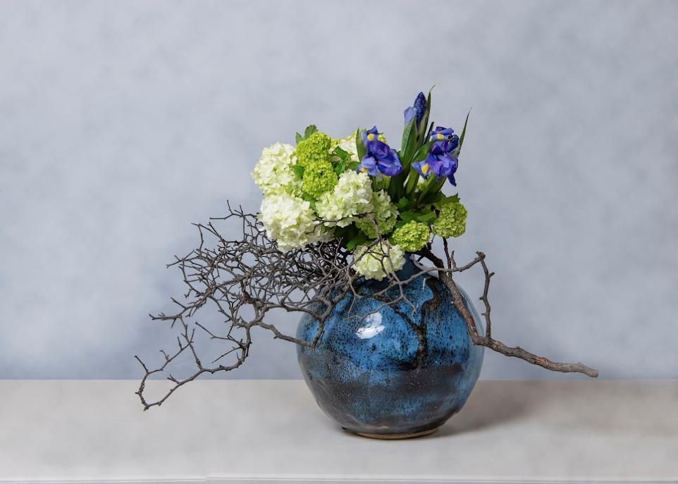 Flower arrangement in a deep blue ceramic vessel 