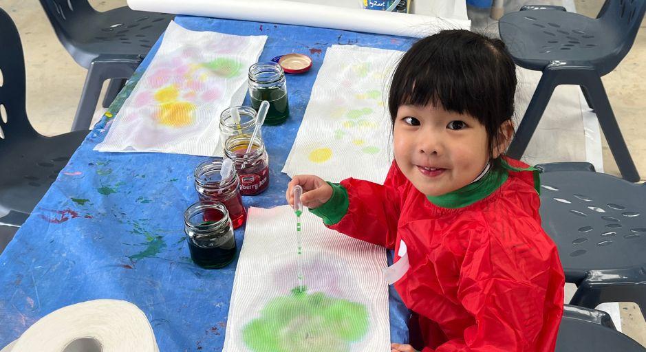 Young child playing with messy play arts materials