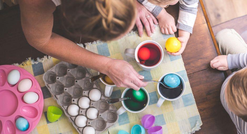 Person colouring easter eggs with food dye