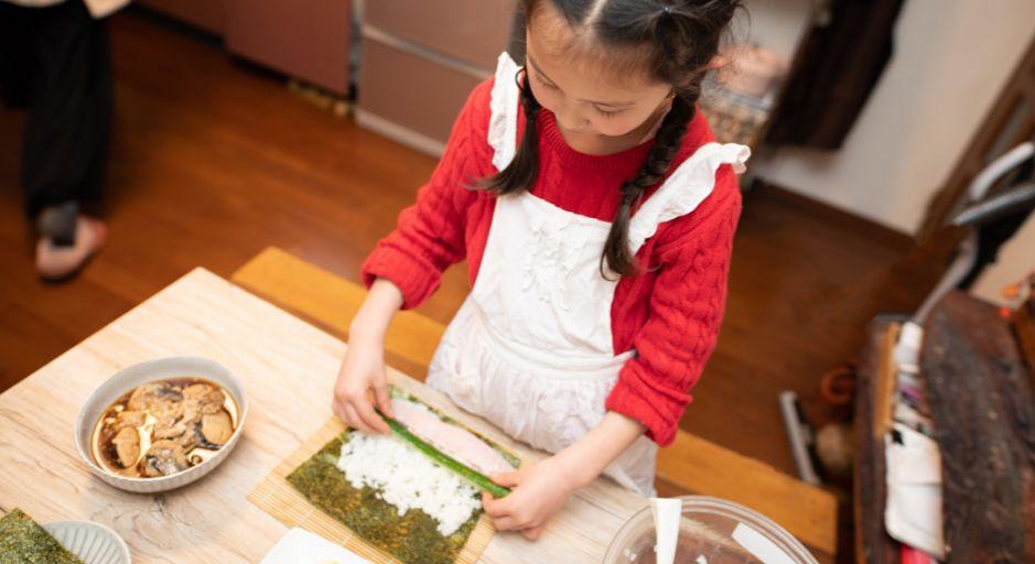 child making sushi hand rolls 