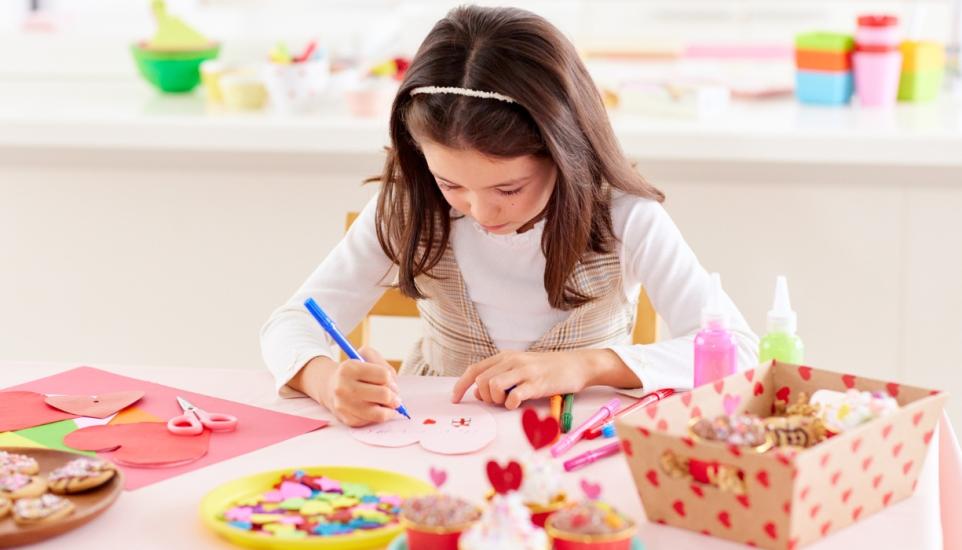child in craft workshop making pop up cards 