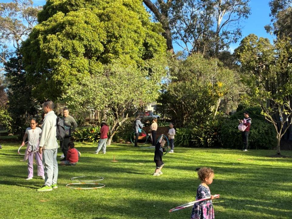 Children in a garden playing with hula hoops