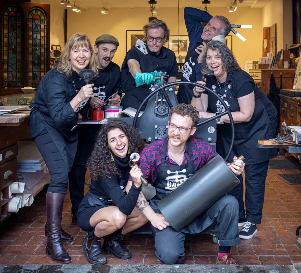 Group of people posing for the camera with printmaking equipment