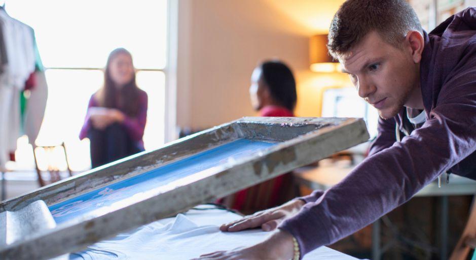 Young person screen printing on white shirt 