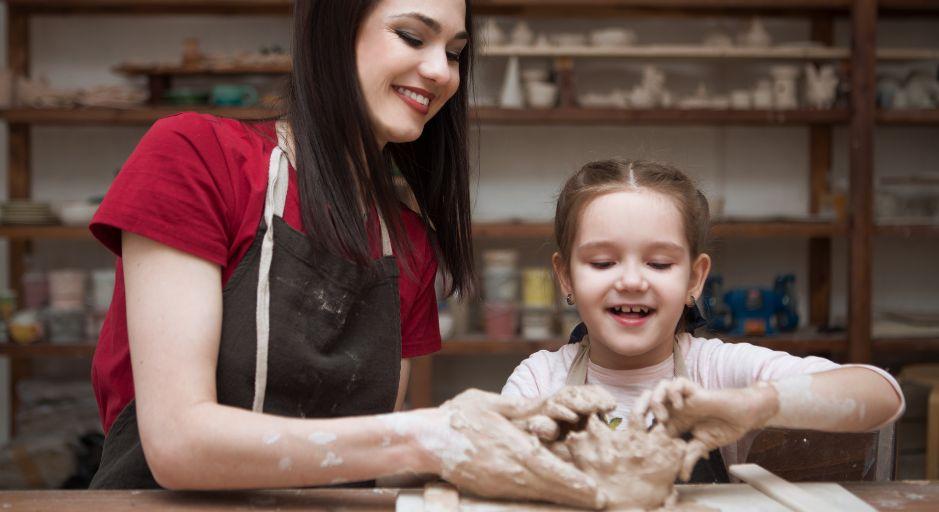 adult and child hand-building with clay 