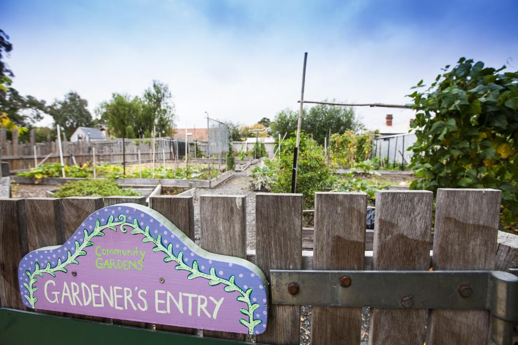 Community gardens - Gardener's entry sign on a fence overlooking plants - including vegetables growing in the gardens