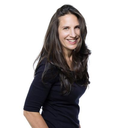 A lady with long brown hair in a black shirt smiling at the camera