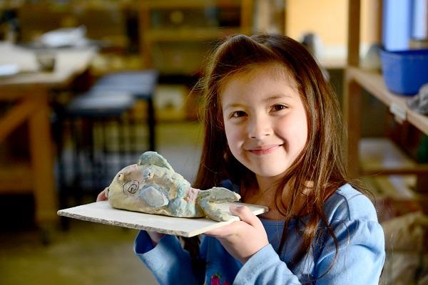 girl holding ceramic fish