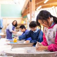 girl making clay at wheel