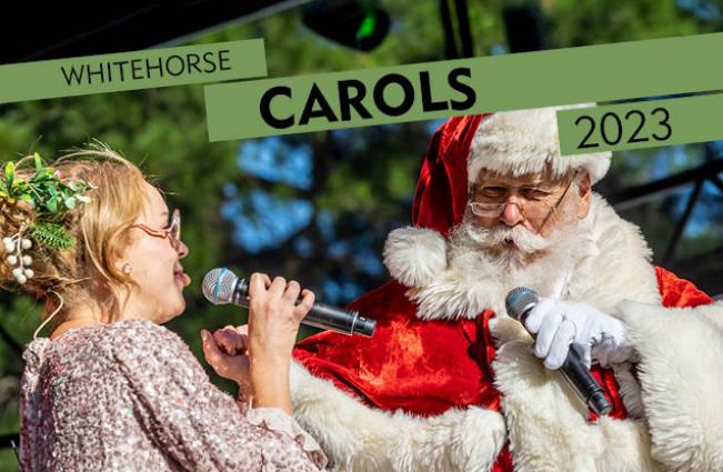 Woman singing into a microphone with a singing male santa