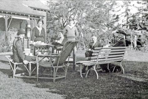 Black and White photograph of a family having a picnic with outdoor furniture