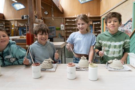 children painting ceramic art works