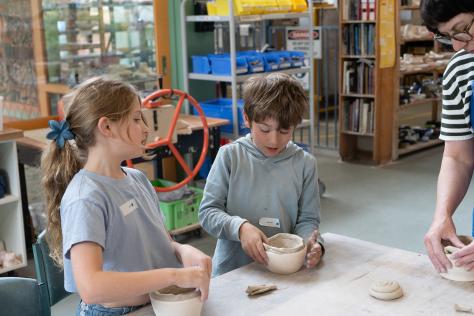 children in ceramic class hand building with clay