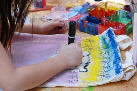 child drawing on fabric tote bag