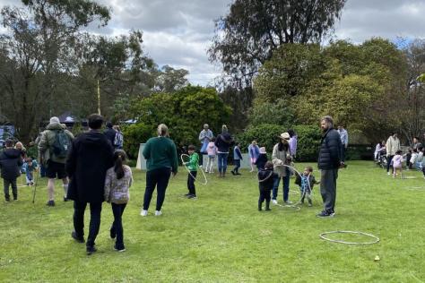 Families playing with hula hoops in a garden