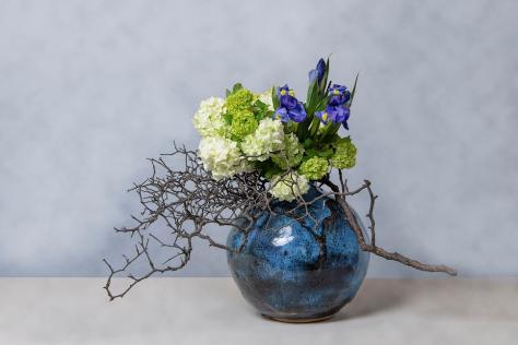 Flower arrangement in a deep blue ceramic vessel 