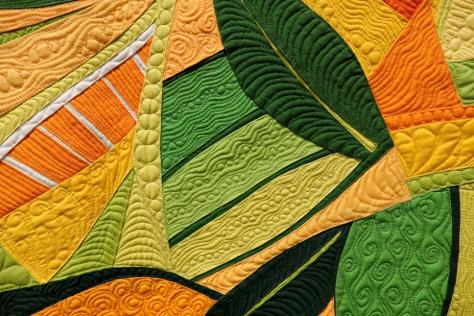 Close up of orange, yellow and green quilt