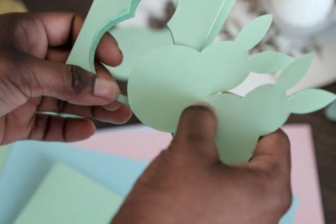 hands creating a paper bunny