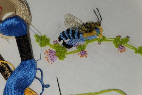 Embroidery showing a stitched bee 
