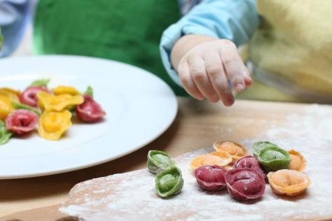 child cooking rainbow pasta 