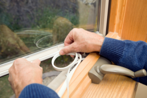 Photograph of a person sealing a window with a rubber seal