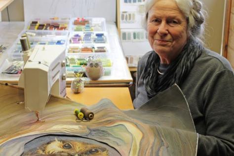 Annemeike Mein looking at the camera while working on a textile