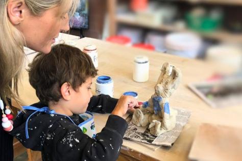 Child and parent painting clay artwork in kindy clay session
