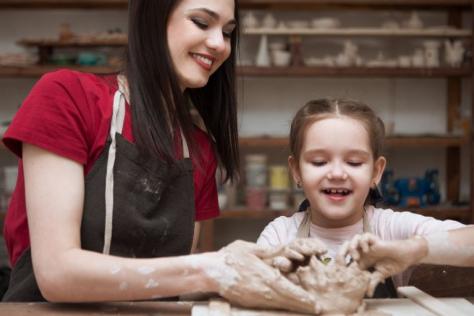 adult and child hand-building with clay 