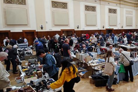 View looking over people examining market stalls in a hall.