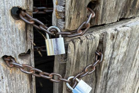 Close up of chains and locks on a wooden door.
