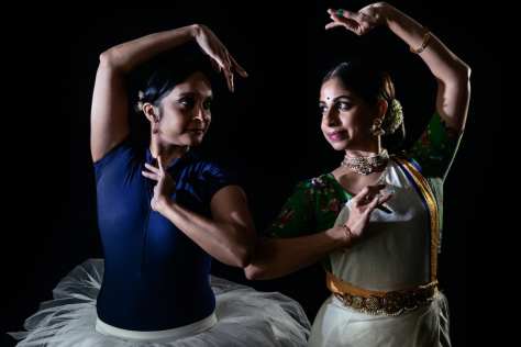 Two woman in dance poses, one in a tutu, the other in classical Indian dress. 