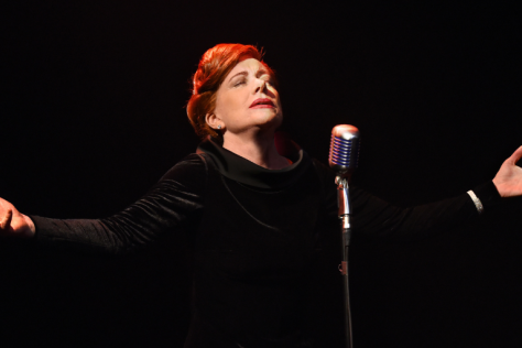 Bernadette Robinson with eyes closed, head tilted upwards and arms spread open