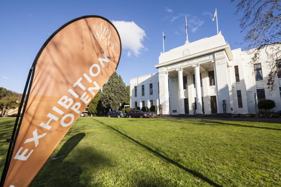 Side shot of Box Hill Town Hall's front façade with a banner reading Exhibition Open