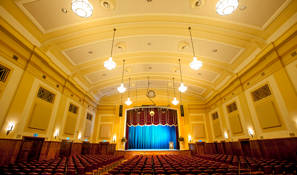 The Box Hill Town Hall's main hall set up with chairs and a blue lit stage