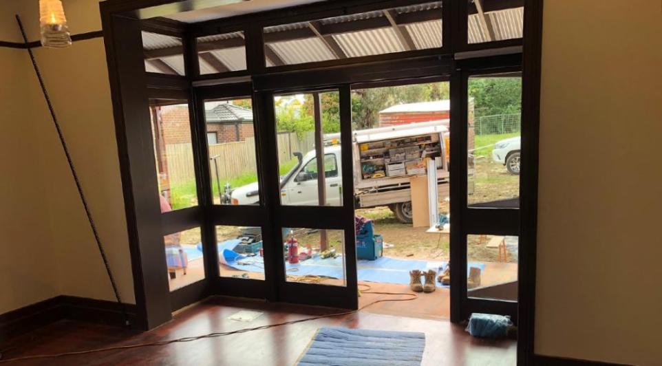 through windowed doors a construction ute is parked in the backyard